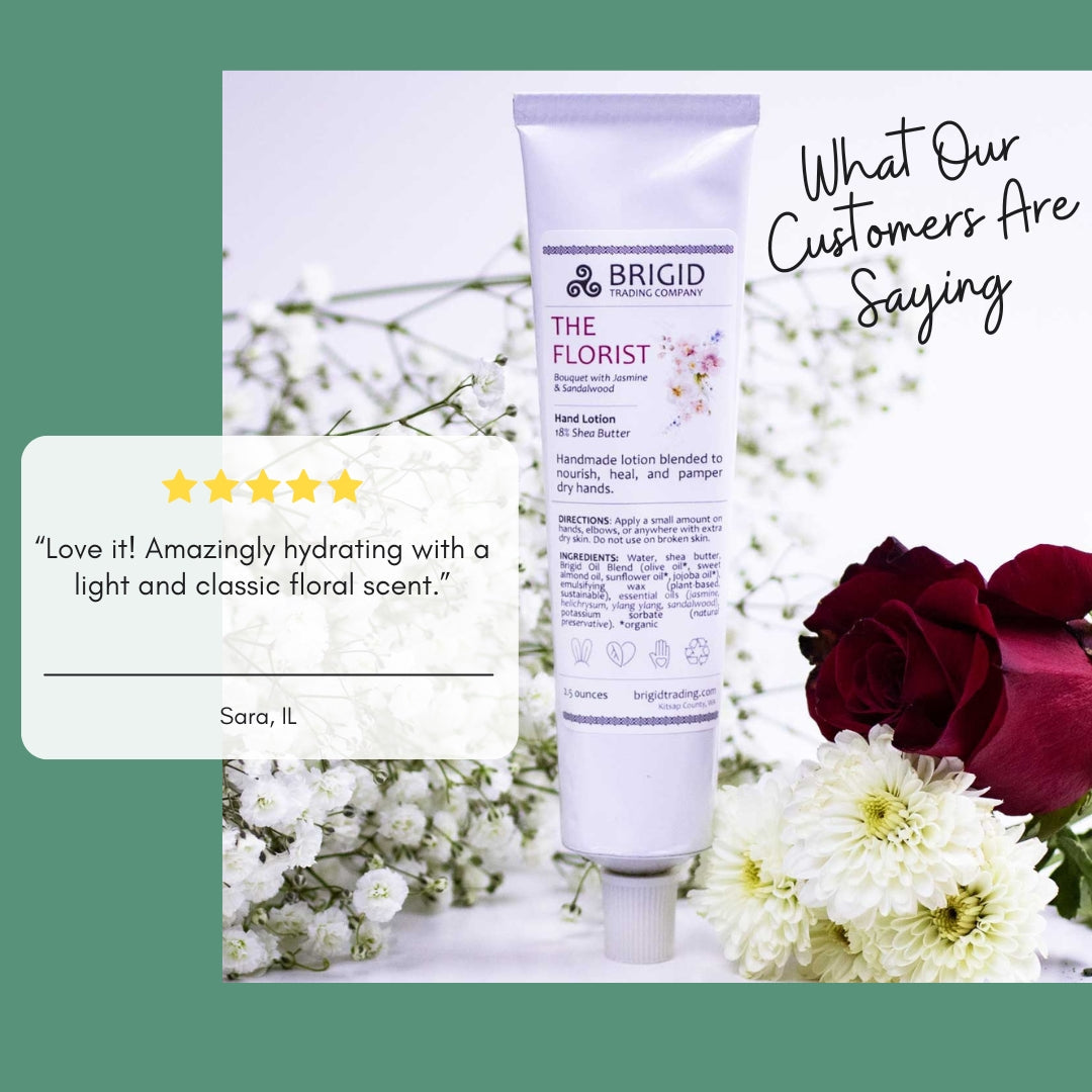 Natural hand lotion tube, white with purple logo; surrounded by flowers