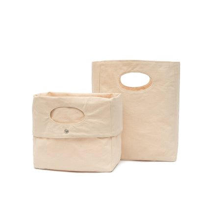 Two light-beige canvas storage baskets with oval handles