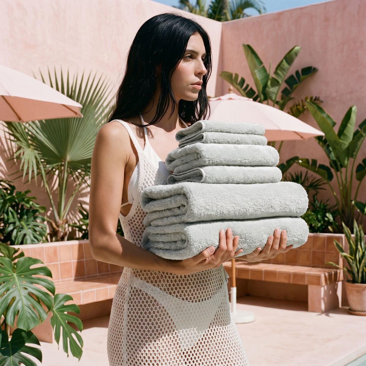 Stack of light gray cotton towels held by person