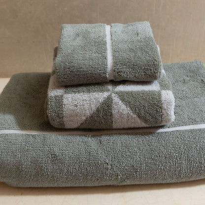Sage green cotton towels with white horizontal stripe, stacked with two top towels