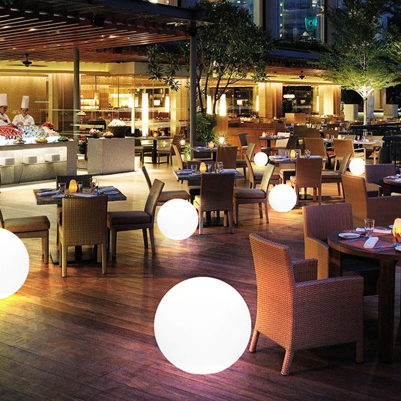 Patio dining area with glowing white LED garden ball lights on tables and floor