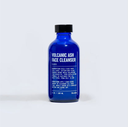 Blue face cleanser bottle with black cap, front label visible