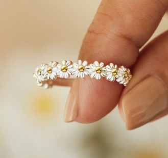 Rotatable daisy flower ring with multiple white blossoms and yellow centers