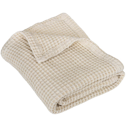 Waffle baby blanket in ivory, neatly folded with textured waffle weave