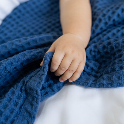 Blue waffle baby blanket with textured diamond knit, folded edge