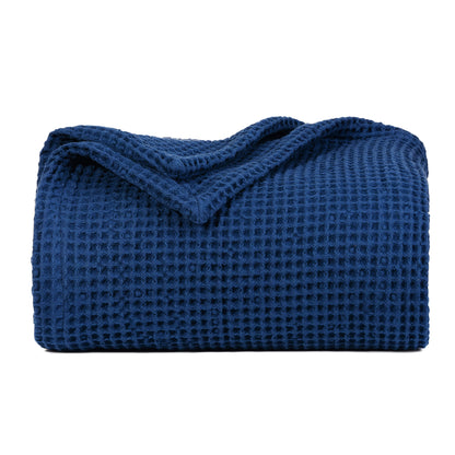 Waffle-weave blanket, folded, dark blue with textured waffle grid.