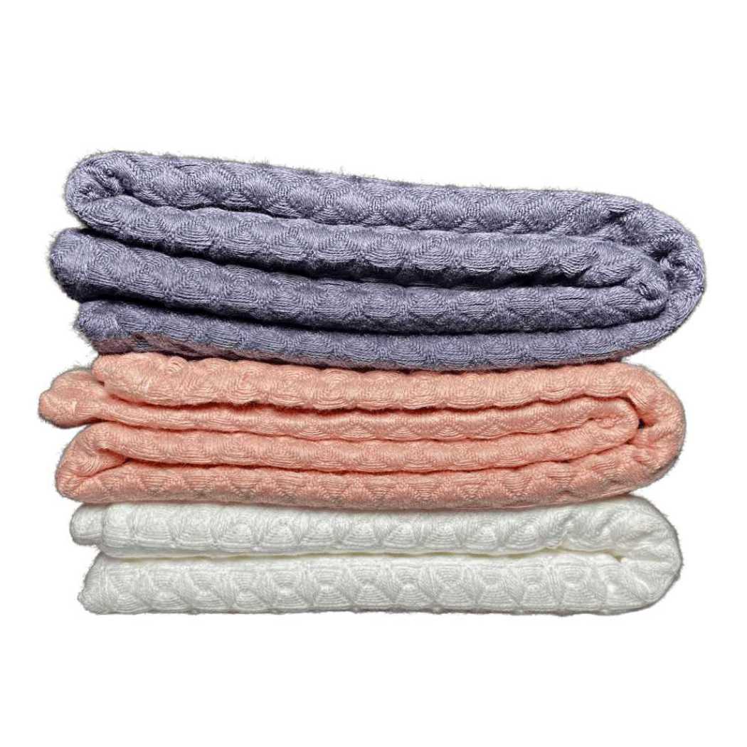 Charcoal gray waffle weave bath towel stack with coral and white.