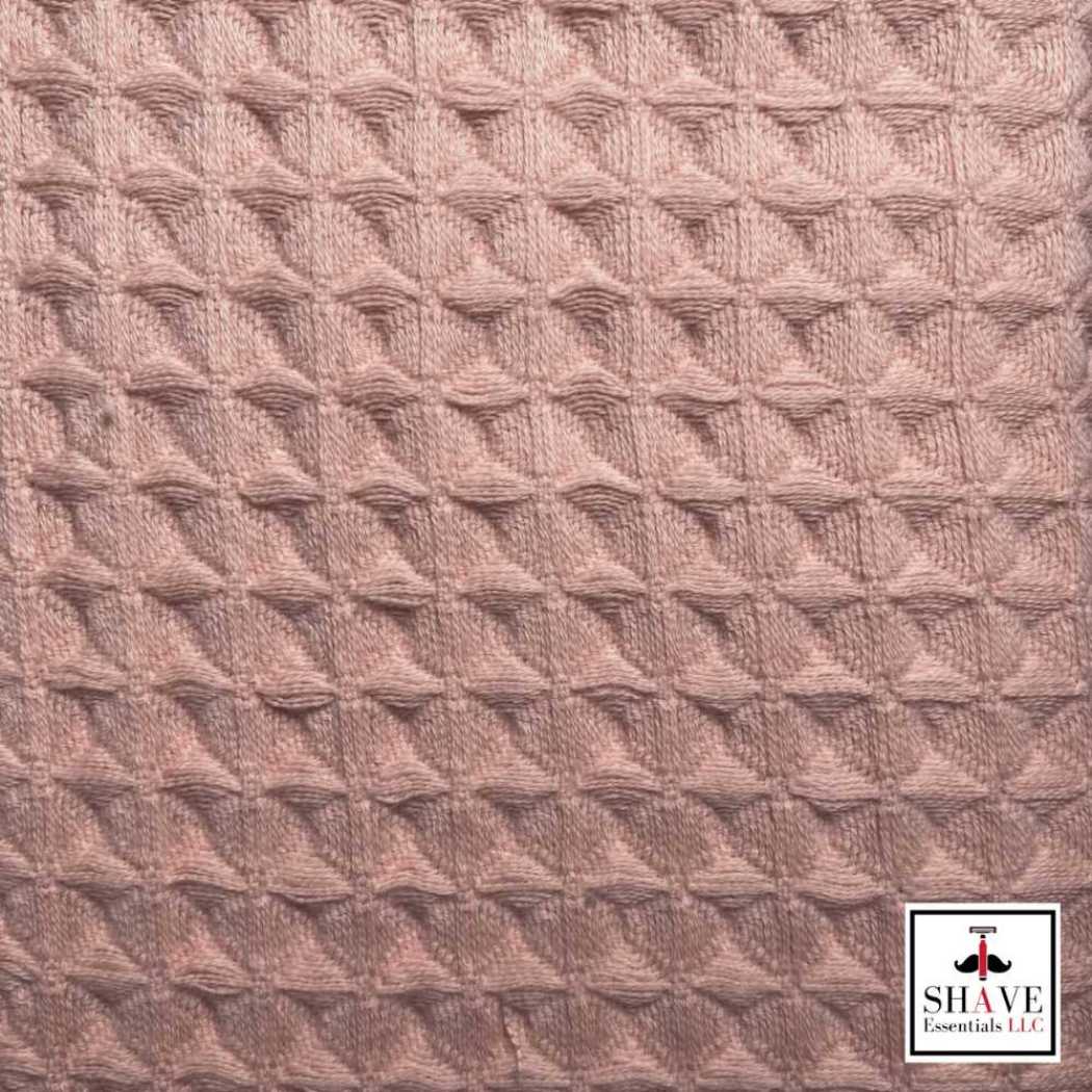 Coral waffle weave bath towel fabric with textured pattern.