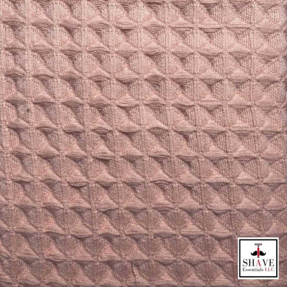 Coral waffle weave bath towel fabric with textured pattern.