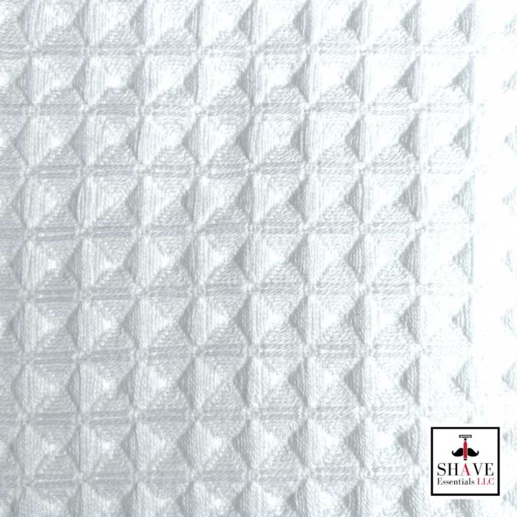 White waffle weave bath towel fabric with textured pattern.