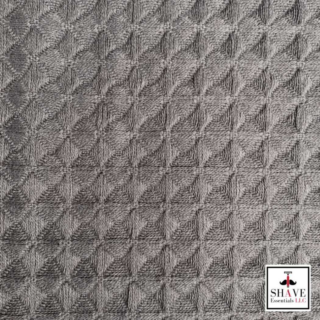 Charcoal gray waffle weave bath towel fabric with textured pattern.