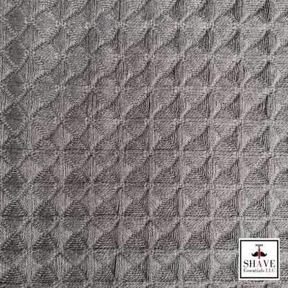 Charcoal gray waffle weave bath towel fabric with textured pattern.