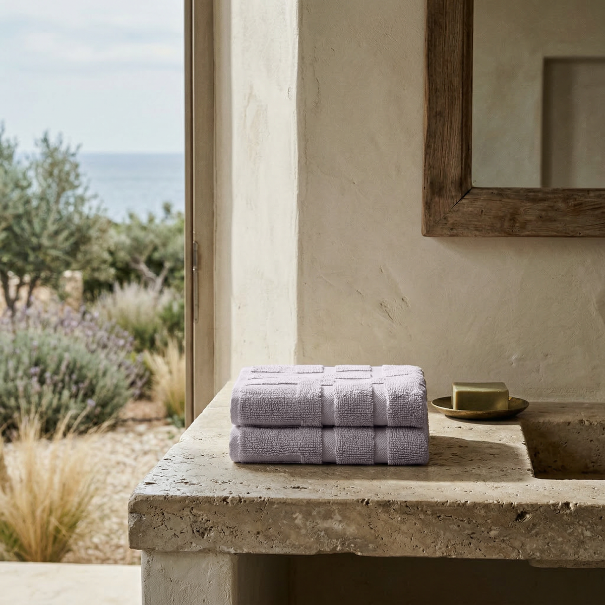 Lilac cotton towels, neatly folded in a stack on a countertop