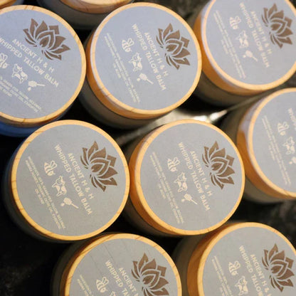 Set of tallow balm jars with blue labels and gold lotus logo on round tops