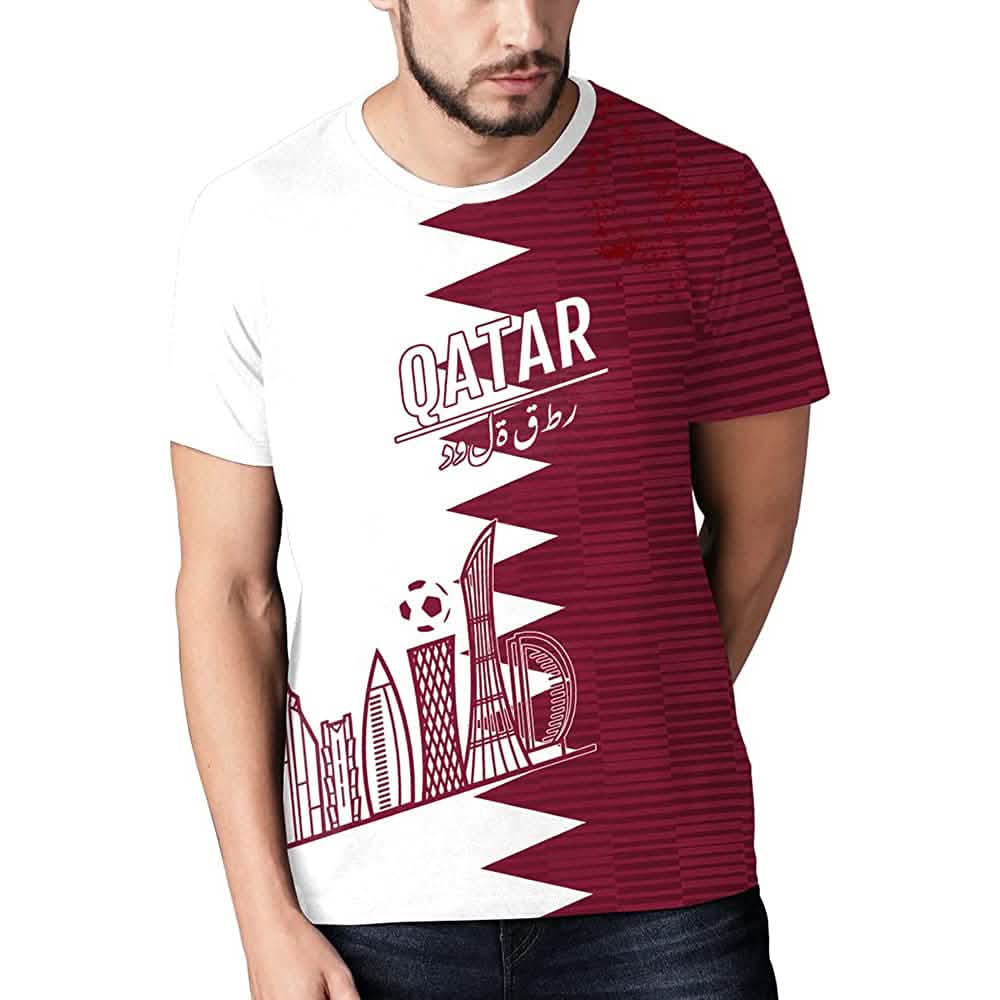 Qatar soccer jersey with maroon right panel, “QATAR” text, and skyline ball graphic.