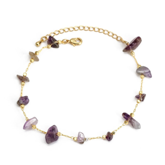 Gold charm bracelet with purple butterfly charms and gold bead accents, secure clasp