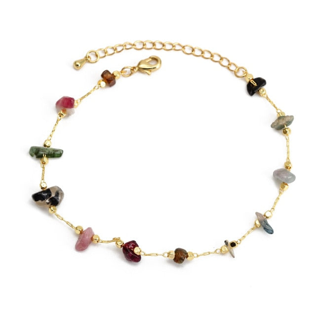 Gold charm bracelet with mixed gemstone charms in pink, black, and green, plus clasp