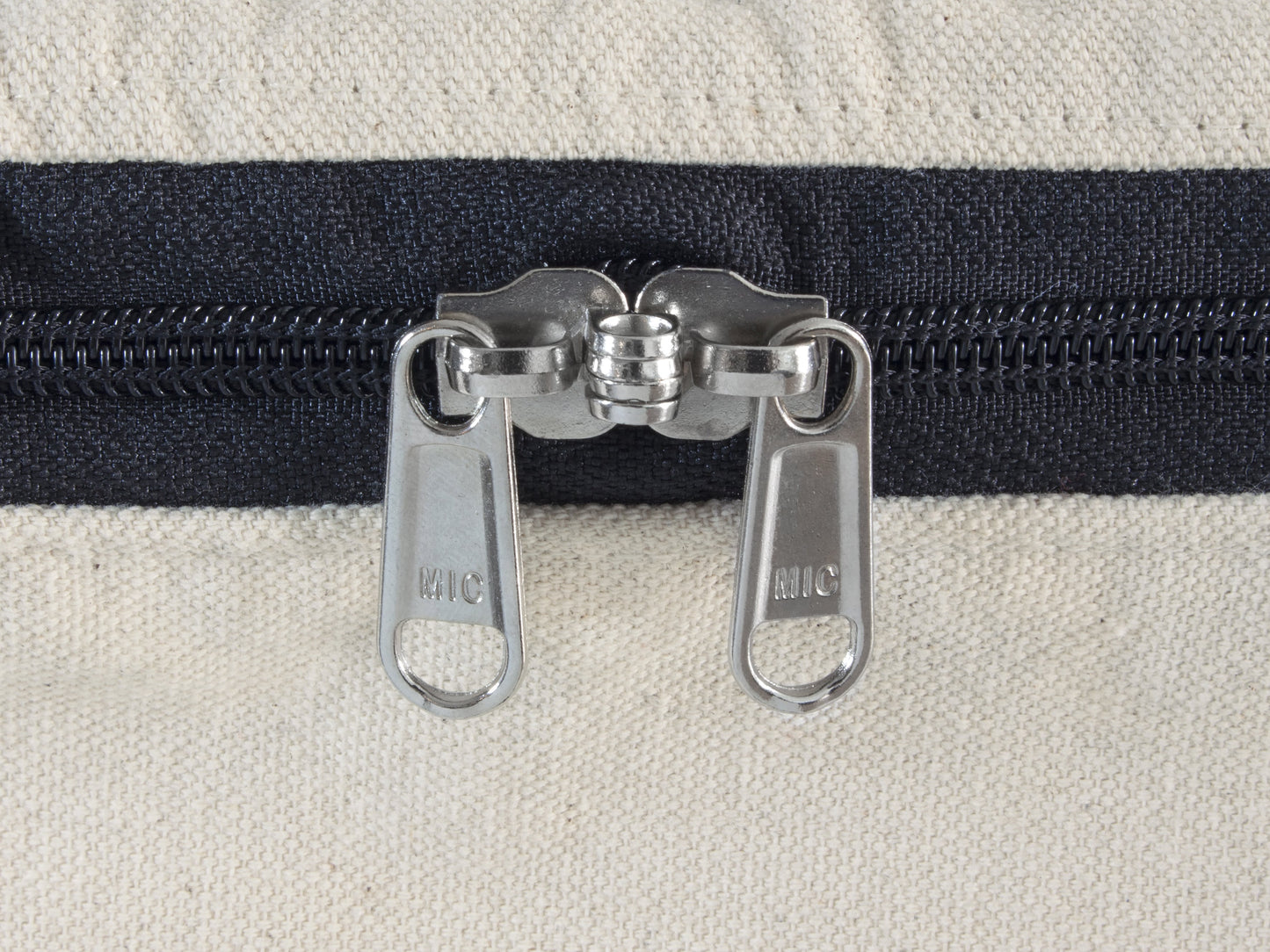Comforter storage bag zipper pull, two metal sliders on dark fabric track