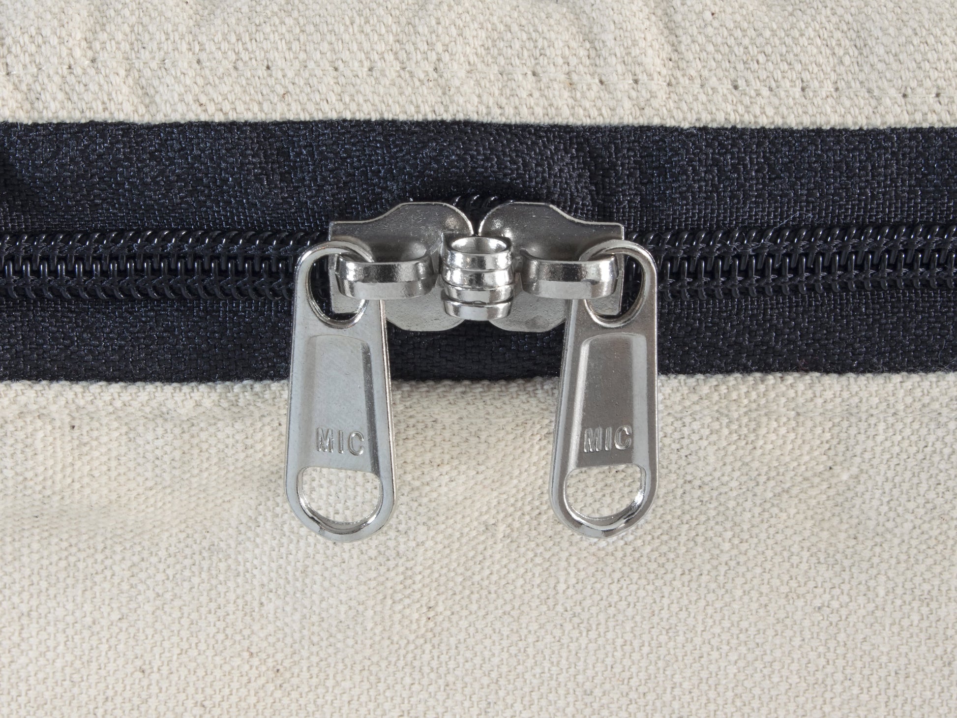 Comforter storage bag zipper pull, two metal sliders on dark fabric track